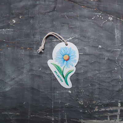 Top view of an eco-friendly cellulose pop-up kitchen sponge featuring a delightful blue daisy pattern, complete with hanging cord. This innovative cleaning tool lies completely flat when dry (just 0.3cm thin) for space-saving storage, then expands to a full 1.5cm thickness when wet for superior absorbency. Made from 100% biodegradable plant-based cellulose, the sponge combines sustainable functionality with charming floral aesthetics - the vibrant blue daisy design adding a cheerful touch to kitchen chores 