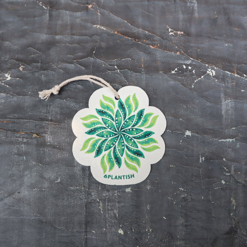 Meet your new kitchen essential - an eco-conscious pop-up sponge that transforms from slim to plump! This top-view reveals its beautiful leaf-print design on biodegradable cellulose. Complete with hanging cord, it smartly switches between space-saving dry mode (flat) and super-absorbent wet mode (expanded), making sustainable cleaning stylish and practical.