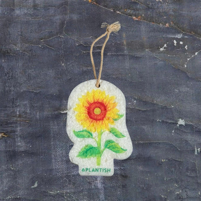 A white pop-up sponge featuring a cheerful sunflower design, with bright yellow petals and vibrant green leaves—adding a touch of nature to your kitchen routine.