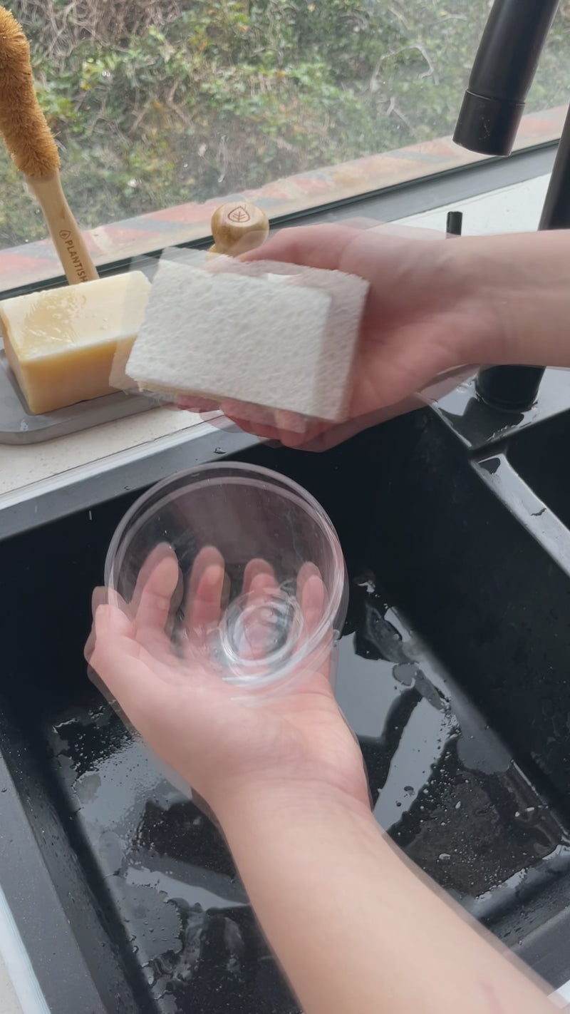 The video showing using contemporary loofah sponge with solid dish soap brick for dishwashing and cleaning in the kitchen. 