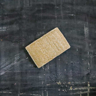 Natural sponge made from sisal fiber. The suds forming from rubbing the eco sponge on the solid dish soap brick.